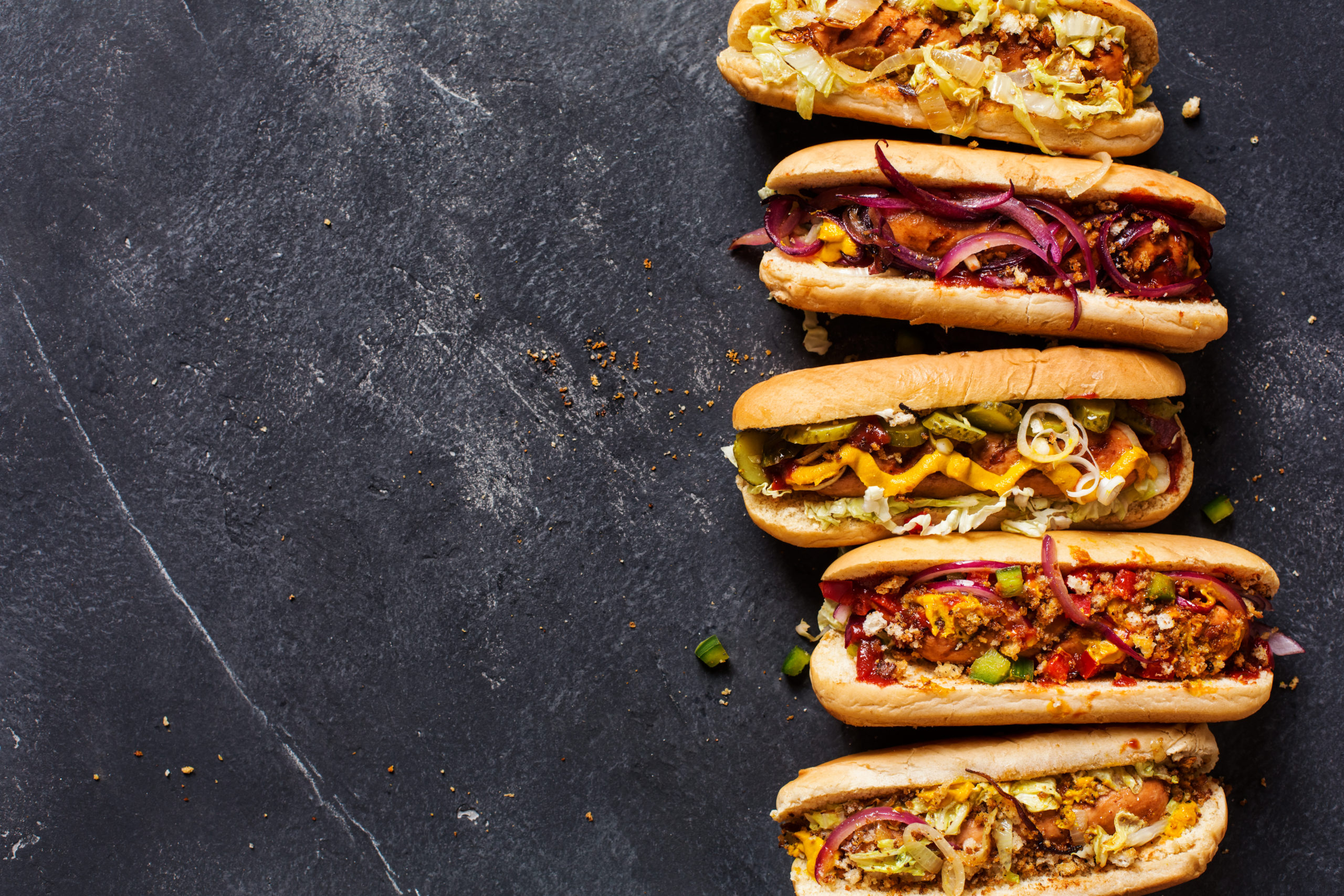 Hot,Dogs,With,Different,Toppings,On,A,Dark,Background.,Food